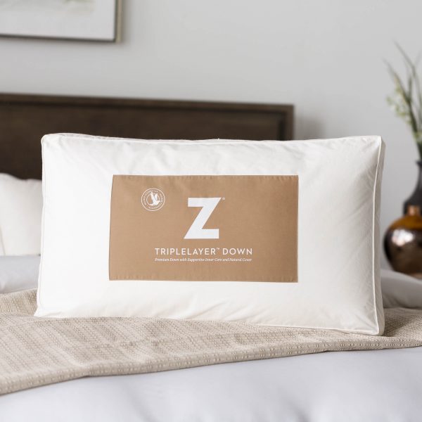 Malouf Z™ TripleLayer™ Down Pillow shown on bed in packaging